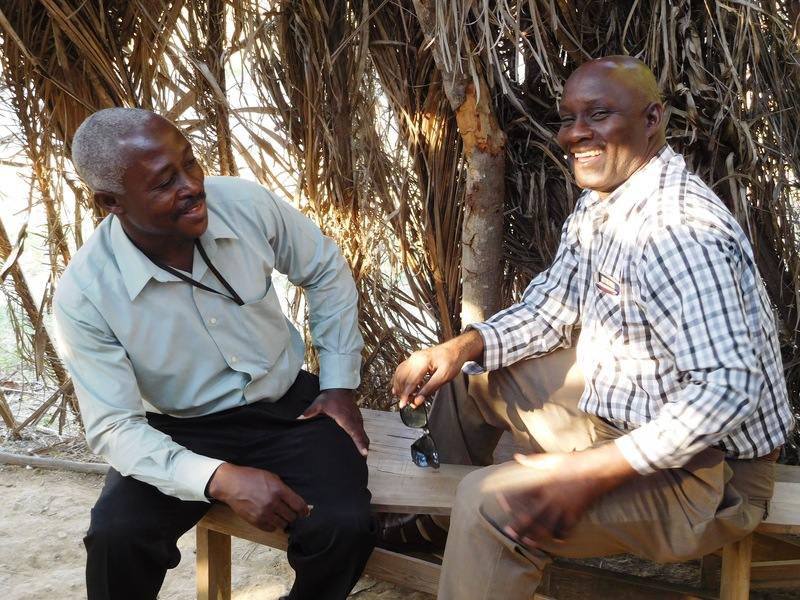 Two men sitting on a banch smiling