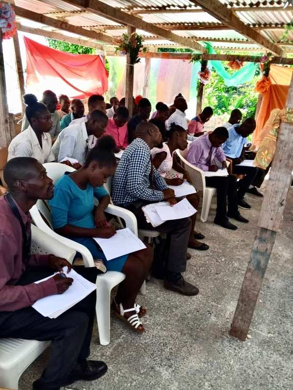 Adult students in a training session in a big tent